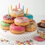 Colorful donut cake featuring glazed donuts and sprinkles